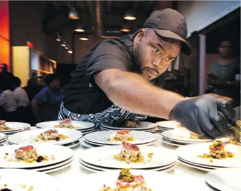  ?? DEB LINDSEY FOR THE WASHINGTON POST ?? Private chef Michael Bowling of Charlotte, N.C., plates the first course at a Soul Food Sessions dinner at Washington’s Mess Hall in late July.