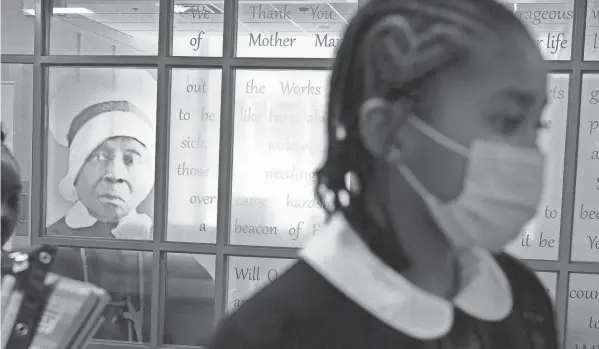  ?? FILE/JACQUELYN MARTIN/AP ?? Students at Baltimore’s Mother Mary Lange Catholic School walk past the chapel decorated with a portrait of Mother Mary Lange, the founder of the order of the Oblate Sisters of Providence.