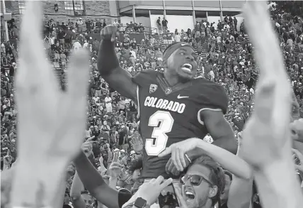  ?? Cliff Grassmick, Daily Camera ?? Colorado’s KD Nixon is picked up by fans to celebrate the 34-31 overtime win over Nebraska on Sept. 7, 2019. Nixon is poised for a breakout season.