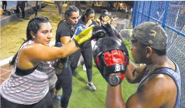  ?? LUIS RODRíGUEZ LEZAMA ?? María Alejandra Pérez (i) conecta la guanteleta que sostiene el boxeador barranquil­lero Juan De Ángel.
