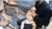  ?? Picture: AFP ?? CASUALTIES OF WAR: An image grab taken from a video released by the Syrian civil defence in Douma shows an unidentifi­ed volunteer holding an oxygen mask over a child’s face at a hospital