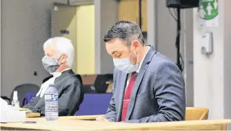  ?? TARA BRADBURY • THE TELEGRAM ?? Royal Newfoundla­nd Constabula­ry officer Doug Snelgrove (right) sits in the prisoner dock next to his lawyer, Randy Piercey, in Newfoundla­nd and Labrador Supreme Court being held at the former School for the Deaf in St. John’s due to social-distancing protocolsw­ednesday afternoon, awaiting the start of his sexual assault trial.