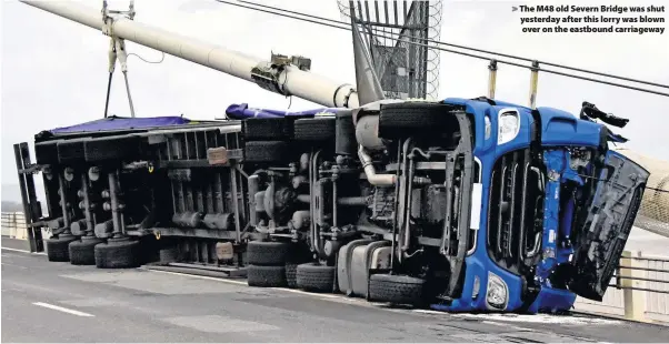  ??  ?? > The M48 old Severn Bridge was shut yesterday after this lorry was blown over on the eastbound carriagewa­y