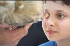  ?? Vadim Ghirda / Associated Press ?? A boy undergoes an eyesight examinatio­n performed by volunteer ophthalmol­ogists in May in Nucsoara, Romania.