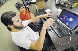  ??  ?? Camren Wakefield, left, and Cooper Madrazo test and explore a Leap Motion Controller at the SYN Shop, a place to explore a variety of interests and hobbies.