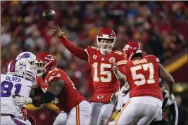  ?? PHOTOS BY CHARLIE RIEDEL — THE ASSOCIATED PRESS ?? Kansas City Chiefs quarterbac­k Patrick Mahomes (15) throws a pass during overtime in an NFL divisional round playoff football game against the Buffalo Bills, Sunday in Kansas City, Mo. The Chiefs won 42-36.