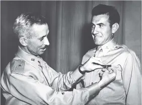  ?? AP FILE PHOTO ?? In this photo taken in 1942, Brig. Gen. Isaiah Davics, commanding general at Midland, Texas, Army Flying School, pins a pair of silver bombardier wings on Lt. Louis Zamperini.