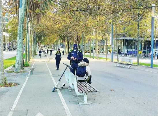  ?? EFE ?? Un guardia con una persona que circula con un patinete por las calles de Barcelona