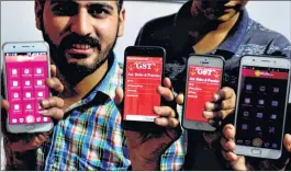  ?? PTI ?? People get some informatio­n about GST through an applicatio­n downloaded on their mobile phones in Amritsar on Friday.