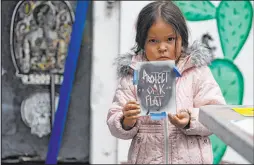  ?? Damian Dovarganes The Associated Press ?? Raetana Manny, 4, shows a sign to save Oak Flat, a site east of Phoenix.
The Apache group is battling a foreign mining firm that wants to build one of the largest copper mines in the United States on what tribal members say is sacred land.