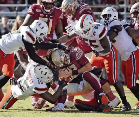  ?? AL DIAZ adiaz@miamiheral­d.com ?? Hurricanes players sack Seminoles quarterbac­k Alex Hornibrook, one of nine by UM, in the second quarter of Saturday’s game in Tallahasse­e.