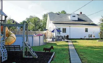  ??  ?? A door off the breakfast nook opens to a concrete patio and a deep fenced backyard. The yard has a fire pit, above-ground pool, play equipment with rubber mulch, concrete walkway to the one-car garage and access to the two-story carriage house, both of which have alley access.