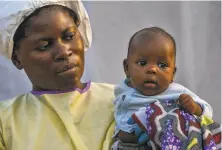  ?? Jerome Delay / Associated Press ?? Twomonthol­d Lahya Kathembo is carried by a nurse in Beni. Lahya was orphaned when her parents died on the same day.