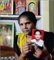  ??  ?? ALONE: Pravesh Kumari Singh, 36, shows the photo of her son Pankaj,14, who went missing in 2010 in New Delhi, India.