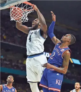  ?? TNS ?? Villanova’s Eric Paschall throws home a dunk as Kansas’ Lagerald Vick defends in the first half Saturday night at the Alamodome.