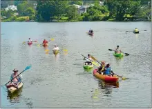  ?? PHOTOS BY SARAH GORDON THE DAY ?? Right, kayaks, canoes and stand-up paddleboar­ds make their way through Alewife Cove. Tuber Nate Gregory preferred the flotilla to a standard Fourth of July parade. “It’s more fun, you just float around, drink beers, it’s a good time,” Gregory said.