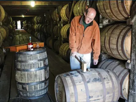  ?? BUFFALO TRACE DISTILLERY VIA THE NEW YORK TIMES ?? Mark Brown, the chief executive of the Sazerac Company, which owns Buffalo Trace, uses a mallet to remove the bung from a barrel in the company’s climate-controlled warehouse.