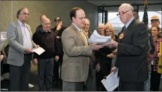  ?? The Sentinel-Record/Mara Kuhn ?? TAKING ON CITY HALL: Cliff Jackson, right, hands Assistant City Manager/City Clerk Lance Spicer a petition Thursday at City Hall in support of a referendum on one of the ordinances the city adopted in December annexing lands that border Lake Hamilton.