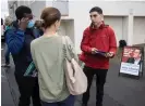  ?? Photograph: Ellen Smith/The Guardian ?? Labor MP for Box Hill, Paul Hamer, talks to people queuing outside a polling centre as early voting opened in the Victorian state election.