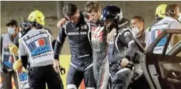  ?? /HAMAD I MOHAMMED / REUTERS ?? Romain Grosjean walks away from the crash scene with the help of medical officers.