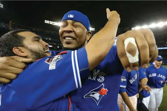  ?? STEVE RUSSELL/TORONTO STAR ?? Dioner Navarro and Edwin Encarnacio­n hug on the field after the Blue Jays’ comeback win over the Texas Rangers to advance in the playoffs. The Jays will play in the ALCS beginning Friday.