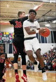  ?? RANDY MEYERS — THE MORNING JOURNAL ?? Lorain’s Taevon Pierre-Louis drives up and under Elyria’s Justin Koepp for the shot during the first quarter.