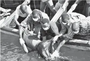  ?? — Gambar Reuters ?? OPERASI MENYELAMAT: Beberapa anggota penyelamat mengangkat mayat seorang lelaki dari air selepas sebuah feri karam di Pulau Ukerewe di Tasik Victoria, Tanzania kelmarin.