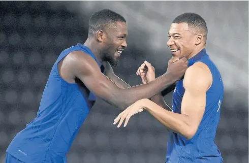  ?? AFP ?? France’s Marcus Thuram, left, jokes with Kylian Mbappe during a training session ahead of their 2022 World Cup opener against Australia today.