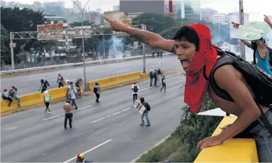  ?? Picture / AP ?? Anti- government protesters direct their colleagues during running battles with members of the national guard in Caracas.