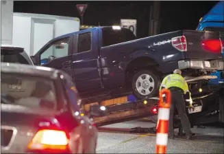  ?? Jonathan Hayward, Canadian Press ?? The pickup truck belonging to murder suspect Travis Baumgartne­r is loaded onto a flatbed truck at the Aldergrove, B.C., border crossing on Saturday.