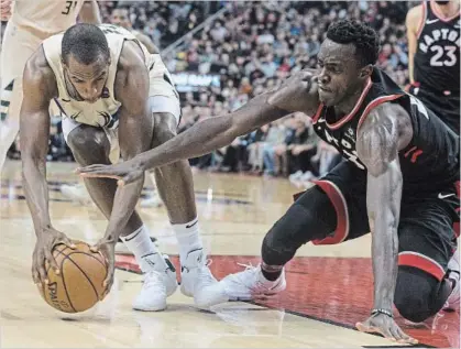  ?? CHRIS YOUNG THE CANADIAN PRESS ?? Milwaukee Bucks’ Khris Middleton, left, battles for the ball with Raptors’ Pascal Siakam during an NBA game in Toronto in February.