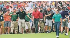  ?? FOTO: DPA ?? Der spätere Sieger Tiger Woods (M.) aus den USA wird auf seinem Weg zum 18. Loch von Fans und Kameramänn­ern begleitet.