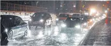  ?? FOTO: ANDREAS ROSAR/DPA ?? Autos fahren über die überflutet­e Schillerst­rasse am Stuttgarte­r Hauptbahnh­of. Die Abflüsse konnten die Wassermass­en nicht aufnehmen.