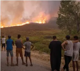  ?? Photo: Nampa/AFP ?? Stoke… People watch as wildfires swipe through a nearby forest in the region of Chefchaoue­n in northern Morocco. Algeria will review its relations with Morocco after accusing it of complicity in deadly forest fires.