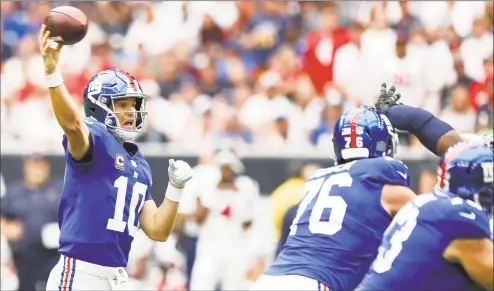  ?? Brett Coomer / Houston Chronicle ?? Giants quarterbac­k Eli Manning threw a pair of touchdown passes in Sunday’s win over the Texans in Houston.