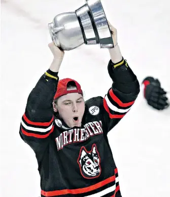  ?? CHARLES KRUPA, THE ASSOCIATED PRESS ?? Adam Gaudette hoists the Beanpot trophy after leading his Northeaste­rn Huskies to a rare victory at the prestigiou­s tournament played in Boston every year.