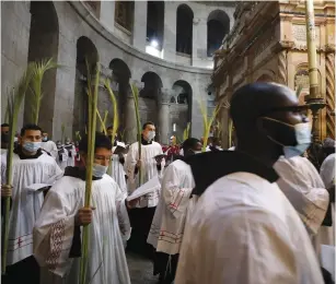 ?? (Ammar Awad/Reuters) ?? CLERGY CARRY palm fronds during the Palm Sunday procession in the Church of the Holy Sepulchre in Jerusalem’s Old City yesterday.