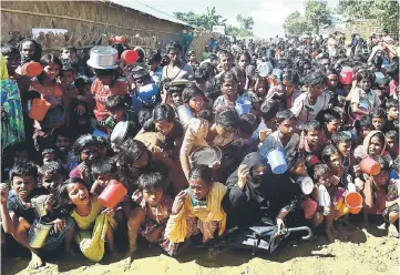  ??  ?? Rohingya refugees wait for food aid at Thankhali refugee camp in Bangladesh’s Ukhia district. — AFP photo