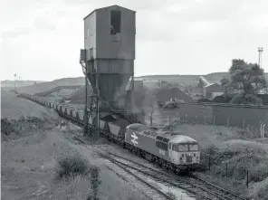 ?? (Ivan Stewart Collection) ?? LEFT: Royston drift mine on June 22, 1988 as 56126 hauls a train of MGRs under the loading bunker before proceeding to Drax. The drift mine at Royston had a short life, opening in 1975 and closing in 1989 after a working life of 14 years.
