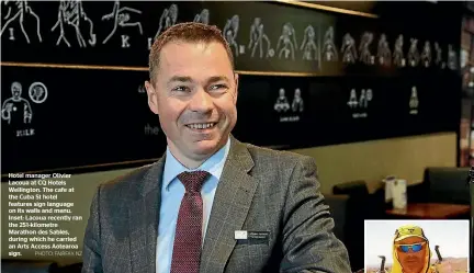  ?? PHOTO: FAIRFAX NZ ?? Hotel manager Olivier Lacoua at CQ Hotels Wellington. The cafe at the Cuba St hotel features sign language on its walls and menu. Inset: Lacoua recently ran the 251-kilometre Marathon des Sables, during which he carried an Arts Access Aotearoa sign.