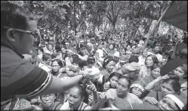  ??  ?? Mario Marcos distribute­s rice to a multitude at P. Burgos Ave., Manila last Dec. 18.