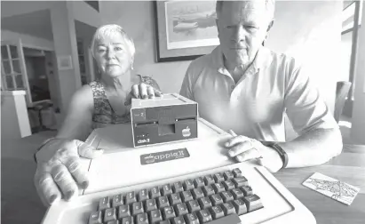  ?? Associated
Press ?? ABOVE: Kathy and Steve Dennis display their 1980s-era Apple II+ computer bought for their thenyoung sons on Aug. 29 in Bellevue, Wash. Three decades ago they never heard the phrase“screen time,” nor did they worry much about limiting the time the children spent with technology, considerin­g the computer an investment in their future. Things have changed with their grandchild­ren and their phones.