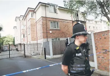  ?? — Reuters photo ?? Police officers stand outside a residentia­l property near to where a man was arrested in the Chorlton area of Manchester, Britain.