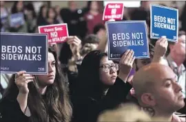  ?? Genaro Molina Los Angeles Times ?? SUPPORTERS AND opponents of a $5-million, 154-bed homeless shelter on Sunset Avenue in Venice raise signs during a City Council meeting at City Hall.