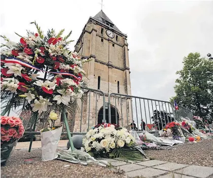  ?? Picture / AP ?? Flower tributes have been left outside the church where 86-year-old priest Father Jacques Hamel died.