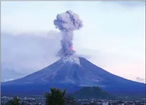  ?? CHARISM SAYAT/AFP ?? A a column of ash shooting up from the Mayon volcano as it continues to erupt, seen from the city of Legazpi in Albay province, south of Manila, yesterday.