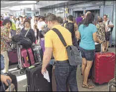  ?? JO KEARNEY / ASSOCIATED PRESS ?? Passengers stand with their luggage outside Terminal 5 at London’s Heathrow Airport on Saturday after flights were canceled due to an IT systems failure on a busy U.K. holiday weekend.