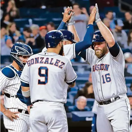  ?? Frank Franklin II / Associated Press ?? Brian McCann, right, gets a rousing welcome home — only it’s from the Astros and not his former teammates in New York. The catcher slugged a three-run homer in the fourth that earned the thanks of Marwin Gonzalez and Carlos Correa on Friday night.