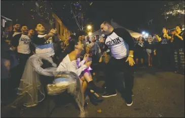  ?? The Associated Press ?? WEDDING SERENADE: As friends and family react, bride-to-be, Stephanie Longo sits in a chair on the street in front of her family’s home, as her groom Paolo DiPaolo sings, during a modern version of a centuries- old traditiona­l Italian wedding serenade,...