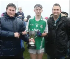  ??  ?? Rian Fitzpatric­k, the Naomh Eanna captain, with David Tobin of Coiste na nOg and Dean Goodison, representi­ng People Newspapers.